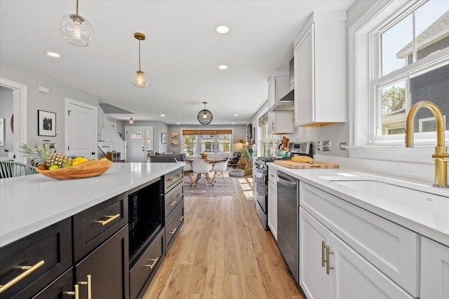 4 Frontrunner Way, Scarborough, ME 04074 - kitchen featuring appliances with stainless steel finishes, a sink, white cabinets, light wood-style floors, and light countertops
