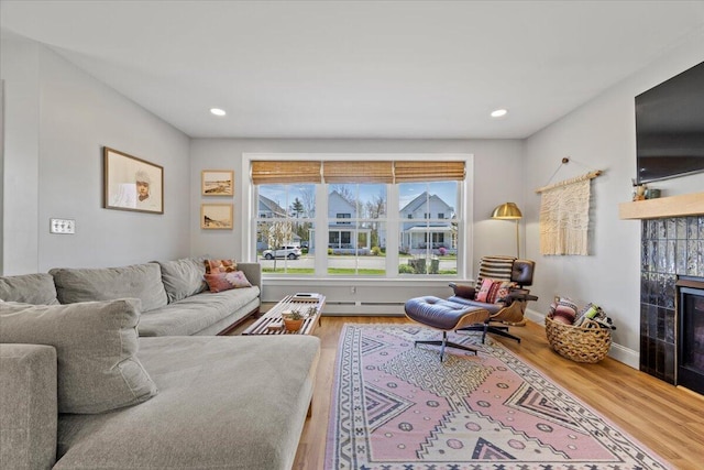 4 Frontrunner Way, Scarborough, ME 04074 - living room featuring a tile fireplace, wood finished floors, a baseboard radiator, recessed lighting, and baseboards
