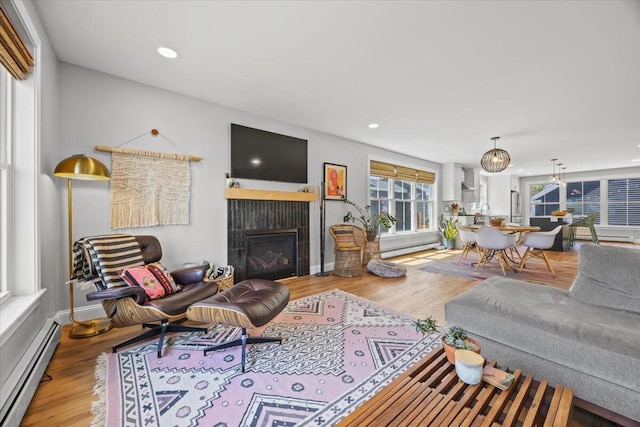 4 Frontrunner Way, Scarborough, ME 04074 - living room featuring a baseboard heating unit, a tiled fireplace, wood finished floors, and recessed lighting