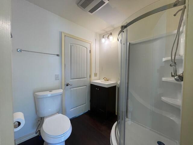 119 Village Rd, Steuben, ME 04680 - bathroom featuring a stall shower, vanity, toilet, and wood finished floors