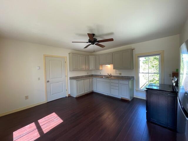 119 Village Rd, Steuben, ME 04680 - kitchen featuring dark wood-style flooring, ceiling fan, a sink, and baseboards