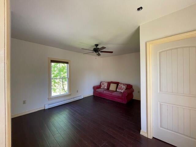 119 Village Rd, Steuben, ME 04680 - unfurnished room featuring a baseboard heating unit, dark wood-type flooring, a ceiling fan, and baseboards