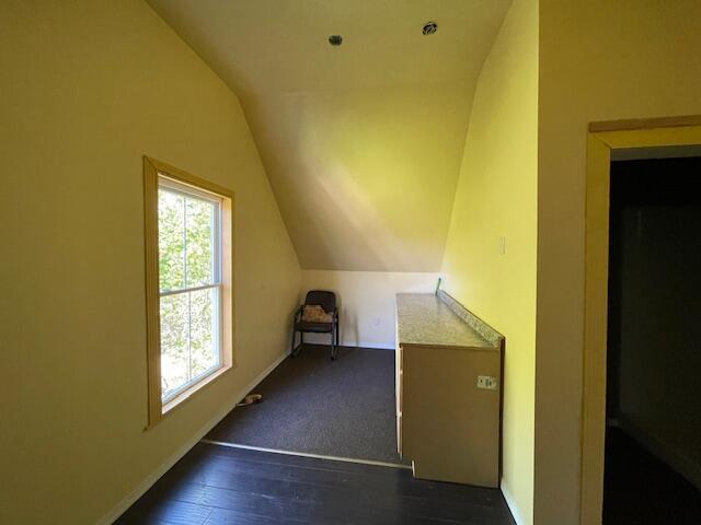119 Village Rd, Steuben, ME 04680 - additional living space with lofted ceiling, dark wood-style floors, and baseboards