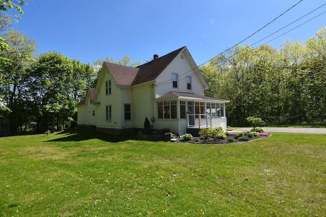 164 Nichols St, Pittsfield, ME 04967 - view of home's exterior with a sunroom, a yard, a chimney, and a shingled roof