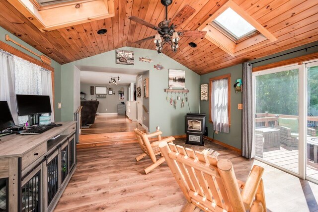 6 Sand Pond Rd, North Berwick, ME 03906 - dining area with a skylight, a wood stove, light wood-style flooring, vaulted ceiling, and a ceiling fan