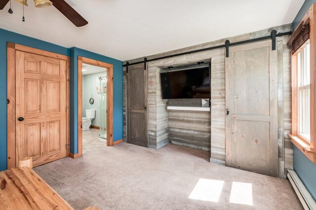 6 Sand Pond Rd, North Berwick, ME 03906 - unfurnished living room with a barn door, a baseboard radiator, carpet flooring, and ceiling fan