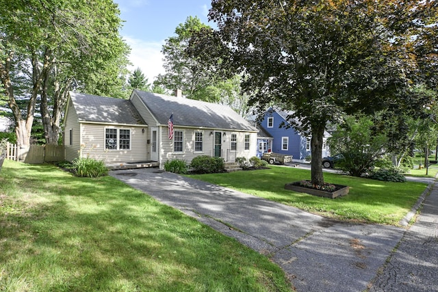 28 Colonial Rd, Westbrook, ME 04092 - view of front of home with asphalt driveway, a chimney, and a shingled roof