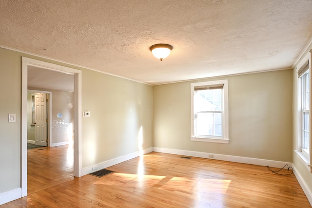 28 Colonial Rd, Westbrook, ME 04092 - empty room with a textured ceiling, light wood-type flooring, ornamental molding, and plenty of natural light