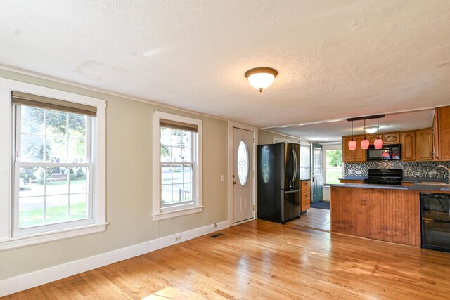 28 Colonial Rd, Westbrook, ME 04092 - kitchen featuring black appliances, beverage cooler, brown cabinets, light wood-style floors, and a textured ceiling