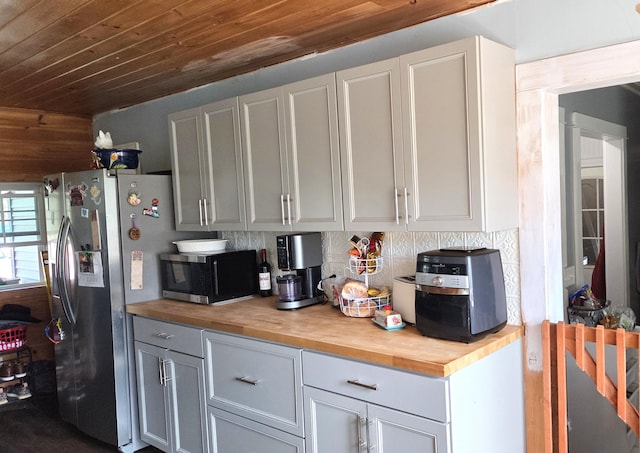 2670 Bennoch Rd, Old Town, ME 04468 - kitchen with butcher block counters, appliances with stainless steel finishes, wooden ceiling, and backsplash