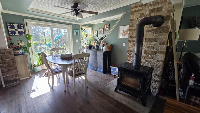 2670 Bennoch Rd, Old Town, ME 04468 - dining room featuring a wood stove, dark wood-style floors, ornamental molding, and a ceiling fan