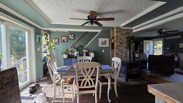 2670 Bennoch Rd, Old Town, ME 04468 - dining area with a wood stove, ceiling fan, crown molding, wood finished floors, and an ornate ceiling