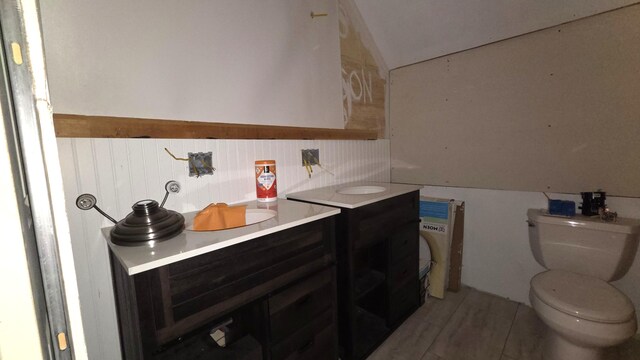 2670 Bennoch Rd, Old Town, ME 04468 - bathroom with vanity, toilet, wood finished floors, and vaulted ceiling