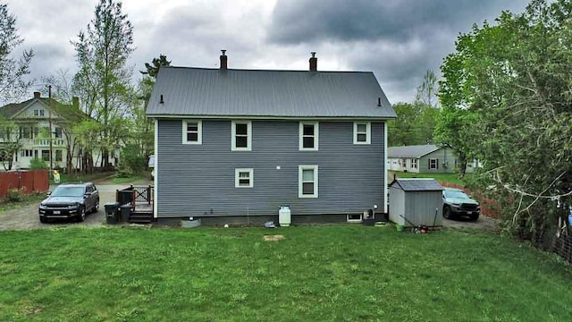 29 Columbia St, Houlton, ME 04730 - back of house featuring a chimney, metal roof, and a yard