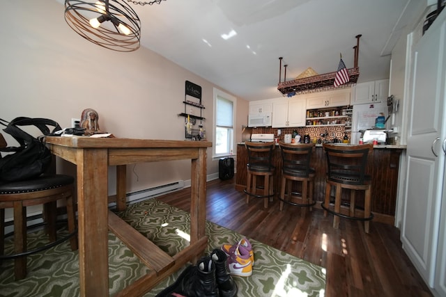 29 Columbia St, Houlton, ME 04730 - dining room featuring a baseboard heating unit, dark wood-type flooring, and a bar