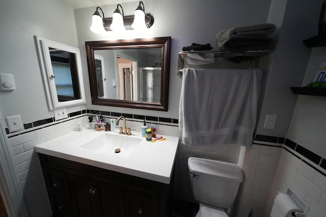 29 Columbia St, Houlton, ME 04730 - bathroom featuring tile walls, toilet, vanity, and a wainscoted wall