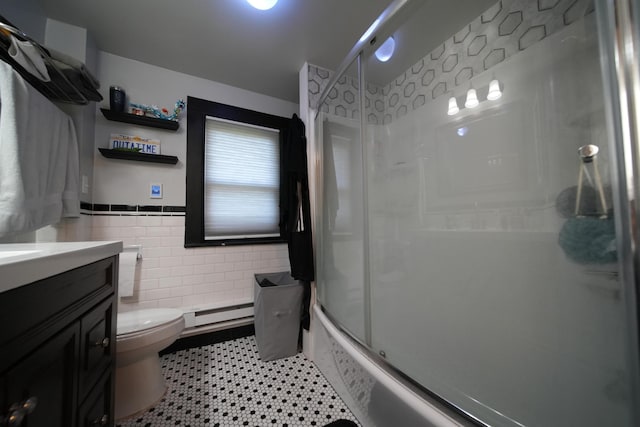 29 Columbia St, Houlton, ME 04730 - full bath featuring tile walls, toilet, a baseboard radiator, vanity, and combined bath / shower with glass door