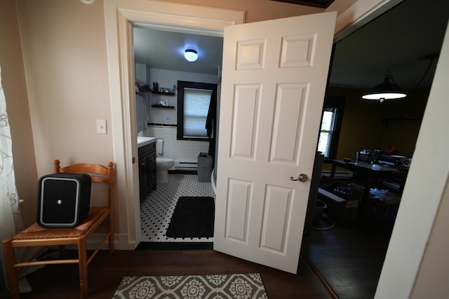 29 Columbia St, Houlton, ME 04730 - hallway featuring a baseboard radiator, dark wood-style flooring, and tile walls