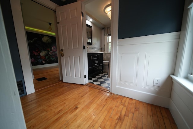 29 Columbia St, Houlton, ME 04730 - unfurnished bedroom with light wood-type flooring, wainscoting, and connected bathroom