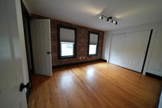 29 Columbia St, Houlton, ME 04730 - unfurnished bedroom with brick wall and wood finished floors