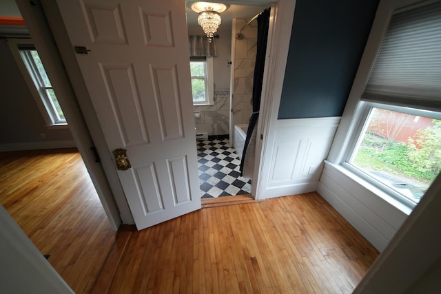 29 Columbia St, Houlton, ME 04730 - empty room featuring a wainscoted wall, light wood-style floors, and a chandelier