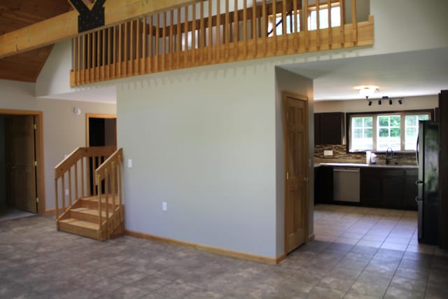 89 Drake Rd, Madison, ME 04950 - unfurnished living room with high vaulted ceiling, stairs, beam ceiling, and a sink