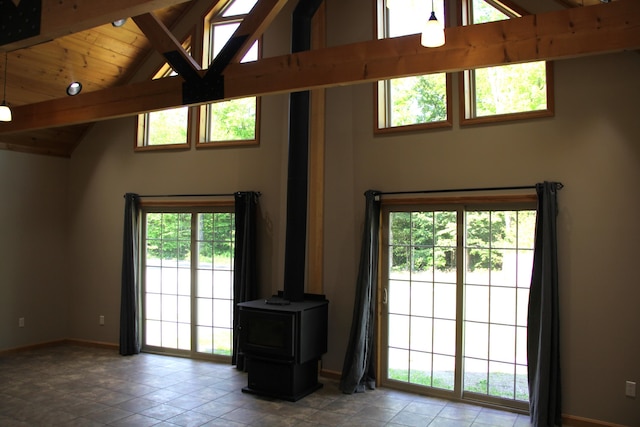 89 Drake Rd, Madison, ME 04950 - living area with baseboards, high vaulted ceiling, tile patterned floors, a wood stove, and wooden ceiling with exposed beams