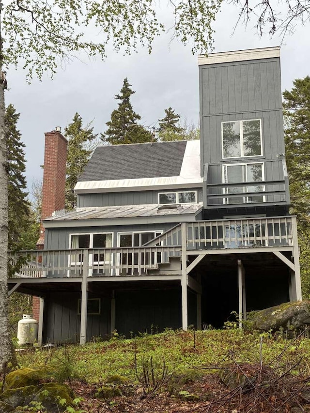 2011 Clark St, Carrabassett Valley, ME 04947 - back of house with roof with shingles, a deck, a chimney, and stairway