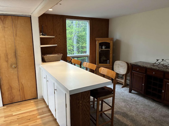 2011 Clark St, Carrabassett Valley, ME 04947 - kitchen with a breakfast bar area, a peninsula, light wood-style flooring, a baseboard radiator, and open shelves