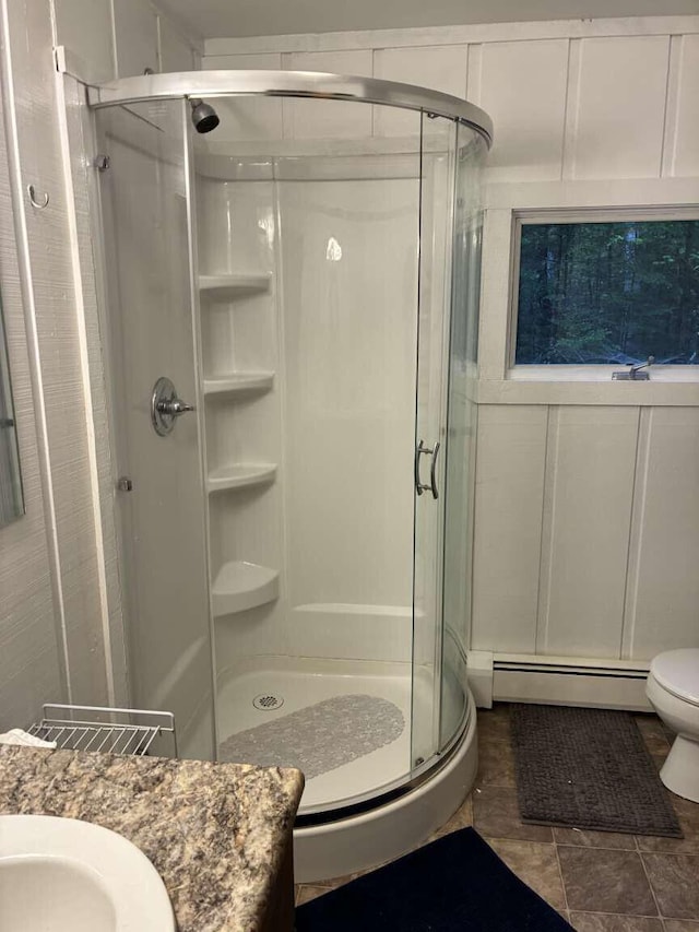 2011 Clark St, Carrabassett Valley, ME 04947 - bathroom featuring a baseboard radiator, a stall shower, vanity, toilet, and tile patterned floors