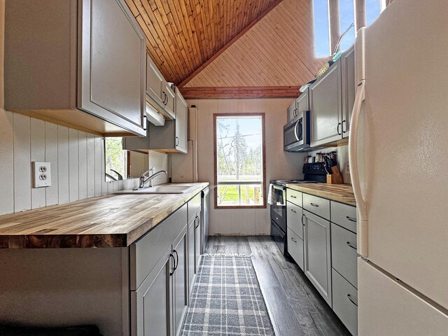 144 Sinclair Rd, Sinclair, ME 04779 - kitchen featuring freestanding refrigerator, black electric range, wooden ceiling, a sink, and stainless steel microwave