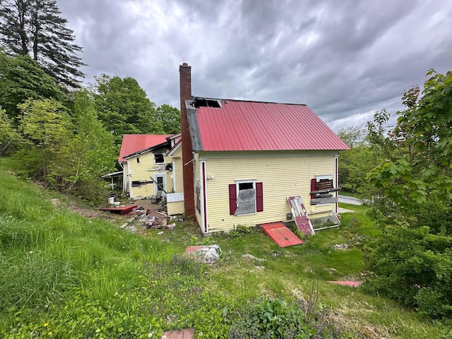 21 High St, Livermore Falls, ME 04254 - rear view of property with a chimney and metal roof
