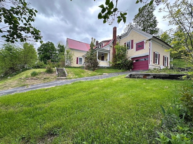 21 High St, Livermore Falls, ME 04254 - victorian home with an attached garage, asphalt driveway, a chimney, a front lawn, and metal roof