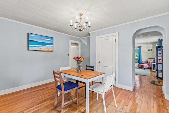 4 Hillside Ave, Biddeford, ME 04005 - dining space featuring arched walkways, light wood-style floors, a chandelier, baseboards, and crown molding
