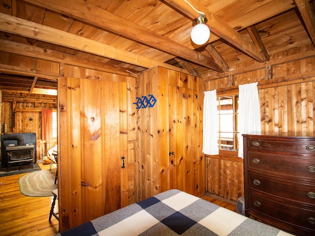44 Cove Ln, Damariscotta, ME 04543 - bedroom featuring a wood stove, wood walls, wood finished floors, and wooden ceiling