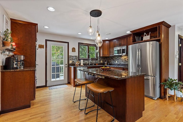 25 Parmenter Ter, China, ME 04358 - kitchen featuring stainless steel appliances, tasteful backsplash, light wood-type flooring, open shelves, and dark stone countertops
