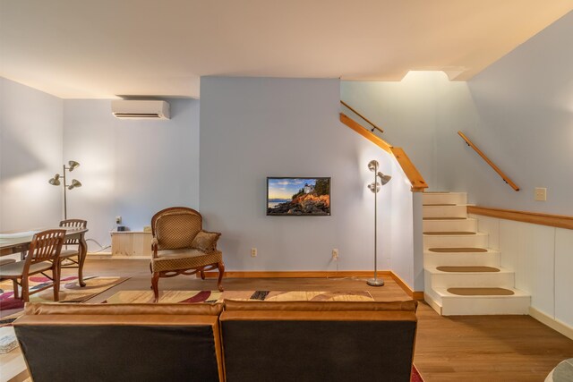 57 Sunset Rd, Dedham, ME 04429 - living room with a wall unit AC, wood finished floors, and stairs