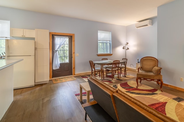 57 Sunset Rd, Dedham, ME 04429 - living area featuring an AC wall unit, wood finished floors, and baseboards