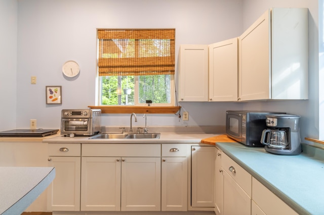 57 Sunset Rd, Dedham, ME 04429 - kitchen with a sink, light countertops, black microwave, and white cabinetry