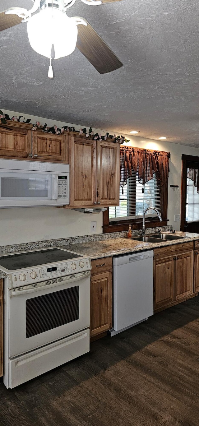 18 Pine St, Skowhegan, ME 04976 - kitchen featuring white appliances, dark wood-style flooring, a sink, brown cabinetry, and a textured ceiling
