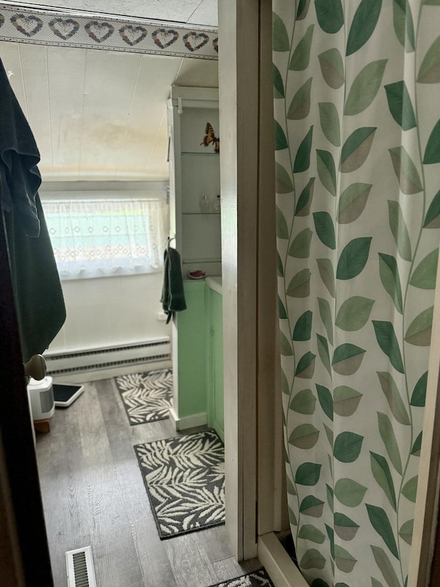 2130 Summerhaven Rd, Sidney, ME 04330 - bathroom with a baseboard radiator, wood finished floors, and a shower with curtain