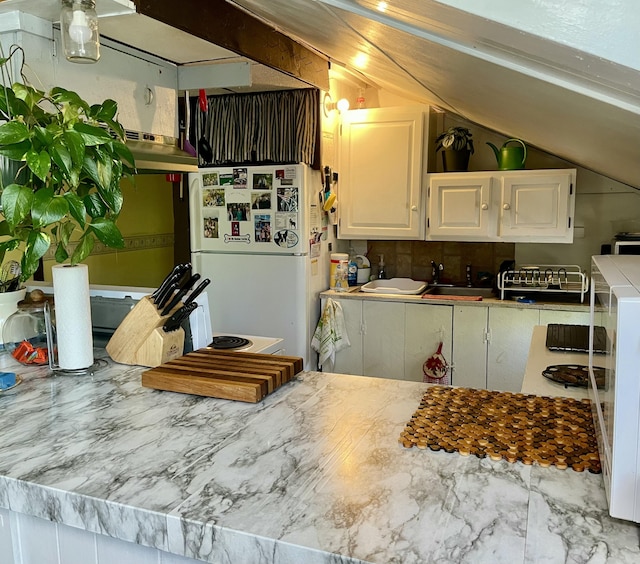 2130 Summerhaven Rd, Sidney, ME 04330 - kitchen featuring freestanding refrigerator, white cabinets, vaulted ceiling, under cabinet range hood, and a sink