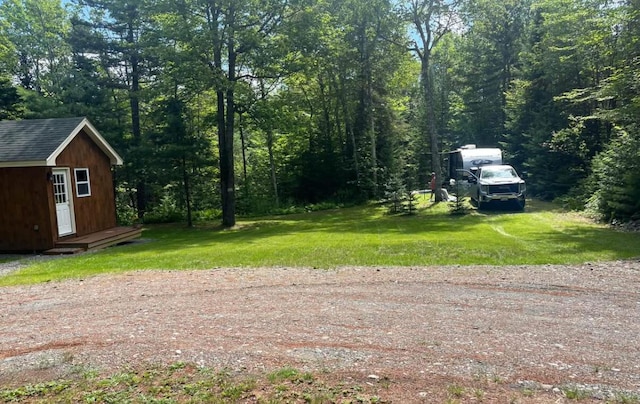 172 Blanchard Rd, Monson, ME 04464 - view of grassy yard featuring an outdoor structure and a forest view
