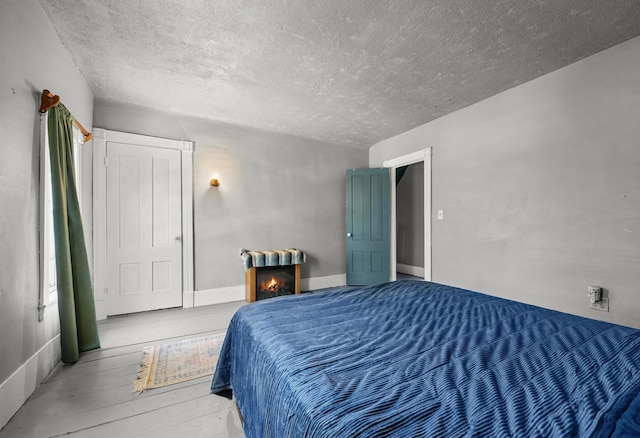 43 Whales Back Rd, Sullivan, ME 04664 - bedroom featuring a textured ceiling and a lit fireplace