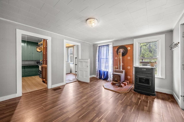 43 Whales Back Rd, Sullivan, ME 04664 - living room featuring a wood stove, dark wood finished floors, crown molding, and baseboards