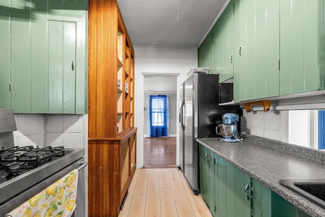 43 Whales Back Rd, Sullivan, ME 04664 - kitchen with green cabinetry, stainless steel appliances, light wood finished floors, dark countertops, and a sink