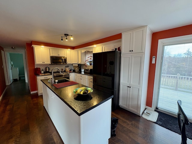 16 Caron Dr, Howland, ME 04448 - kitchen with stainless steel microwave, dark countertops, freestanding refrigerator, decorative backsplash, and white cabinets