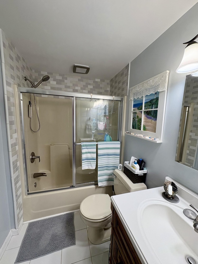 16 Caron Dr, Howland, ME 04448 - bathroom with tile patterned floors, vanity, combined bath / shower with glass door, and toilet