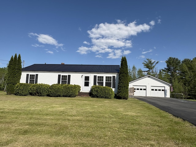 16 Caron Dr, Howland, ME 04448 - view of front of house featuring an outdoor structure, a front lawn, a detached garage, and metal roof