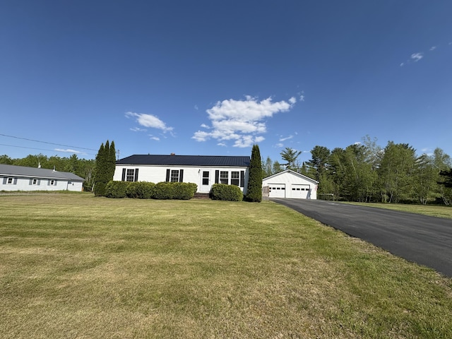 16 Caron Dr, Howland, ME 04448 - view of front of property with a garage, metal roof, a front lawn, and an outbuilding
